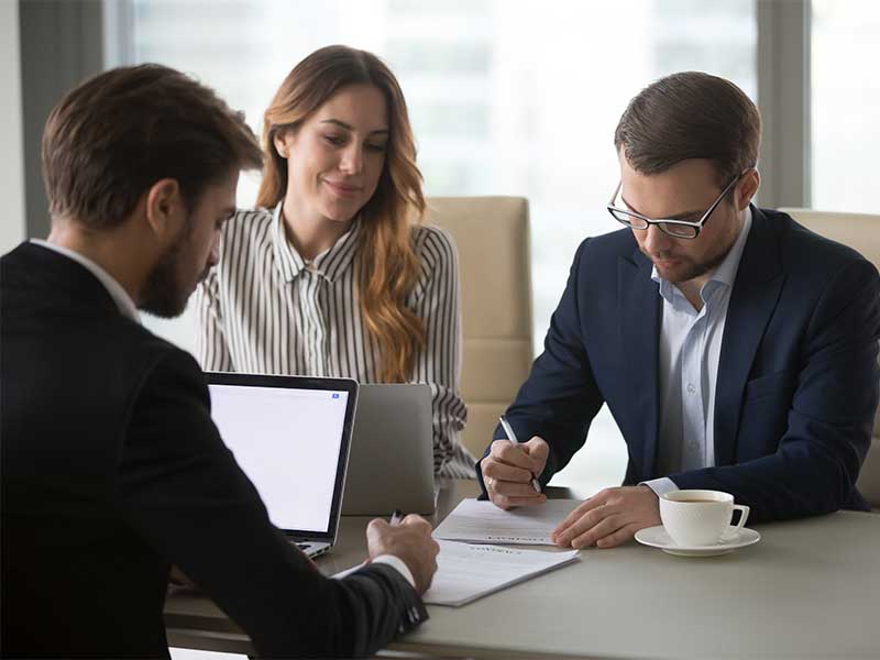 Sales team discussing with a customer at a desk
